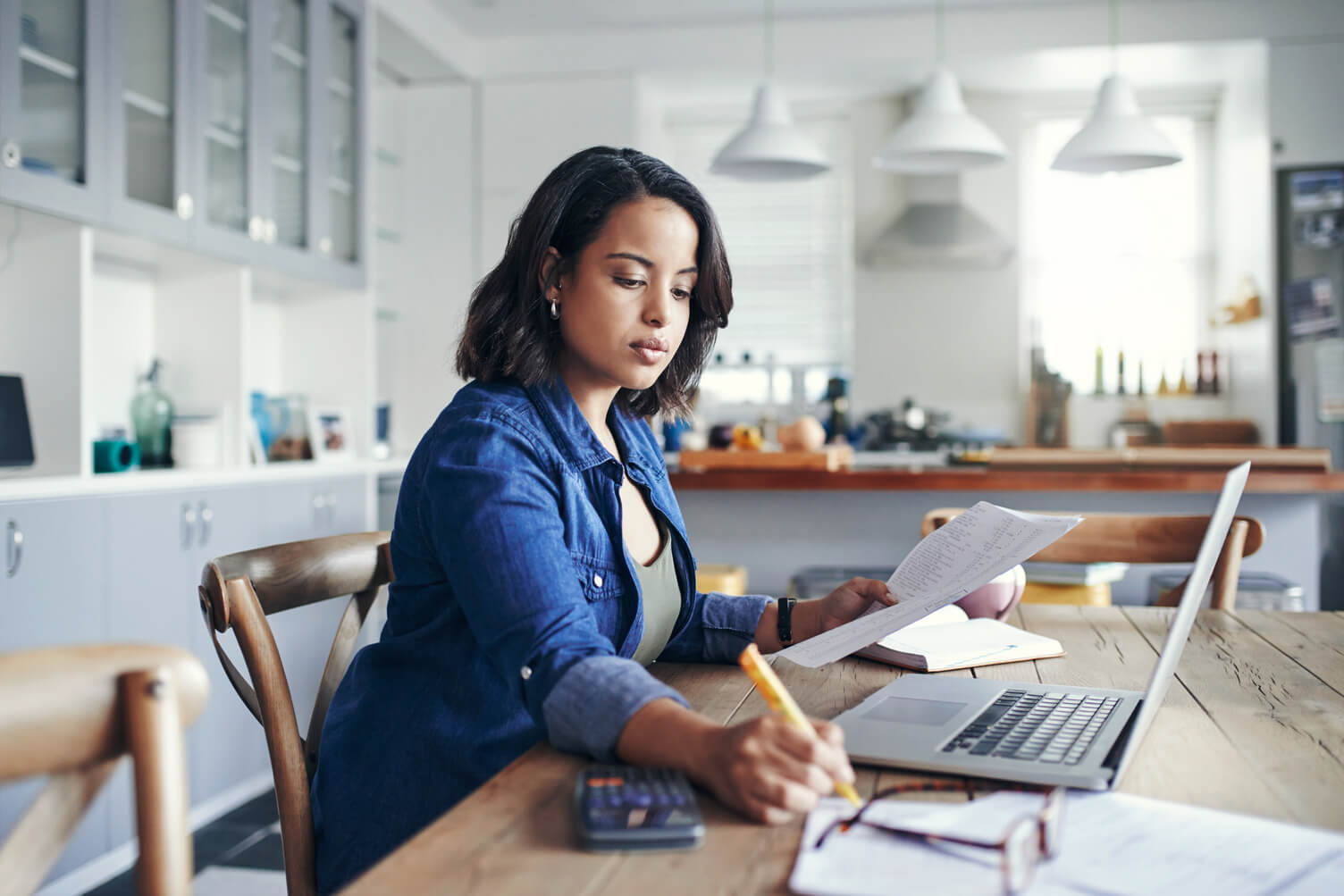 Woman making notes with laptop